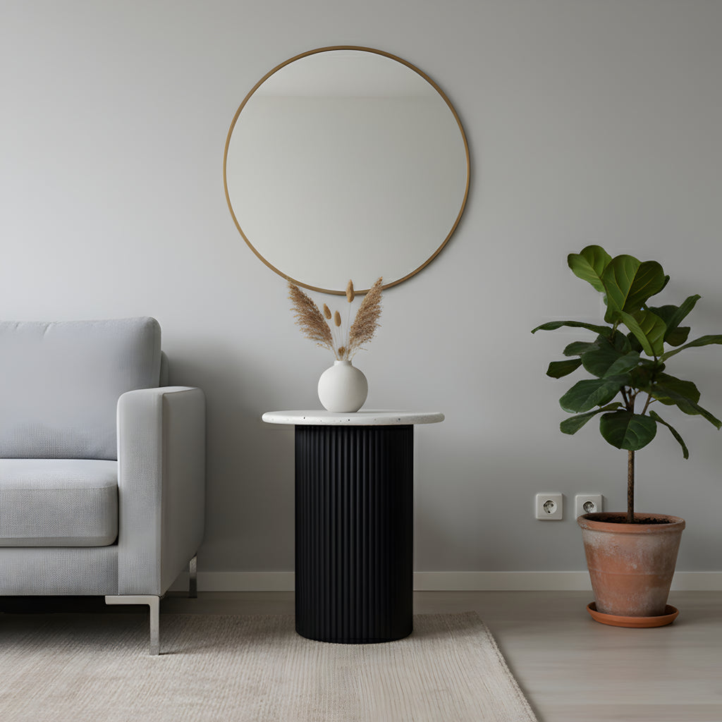 Modern living room with a round mirror, black side table, and potted plant.