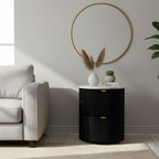 Modern living room with a black side table, white sofa, and decorative mirror.
